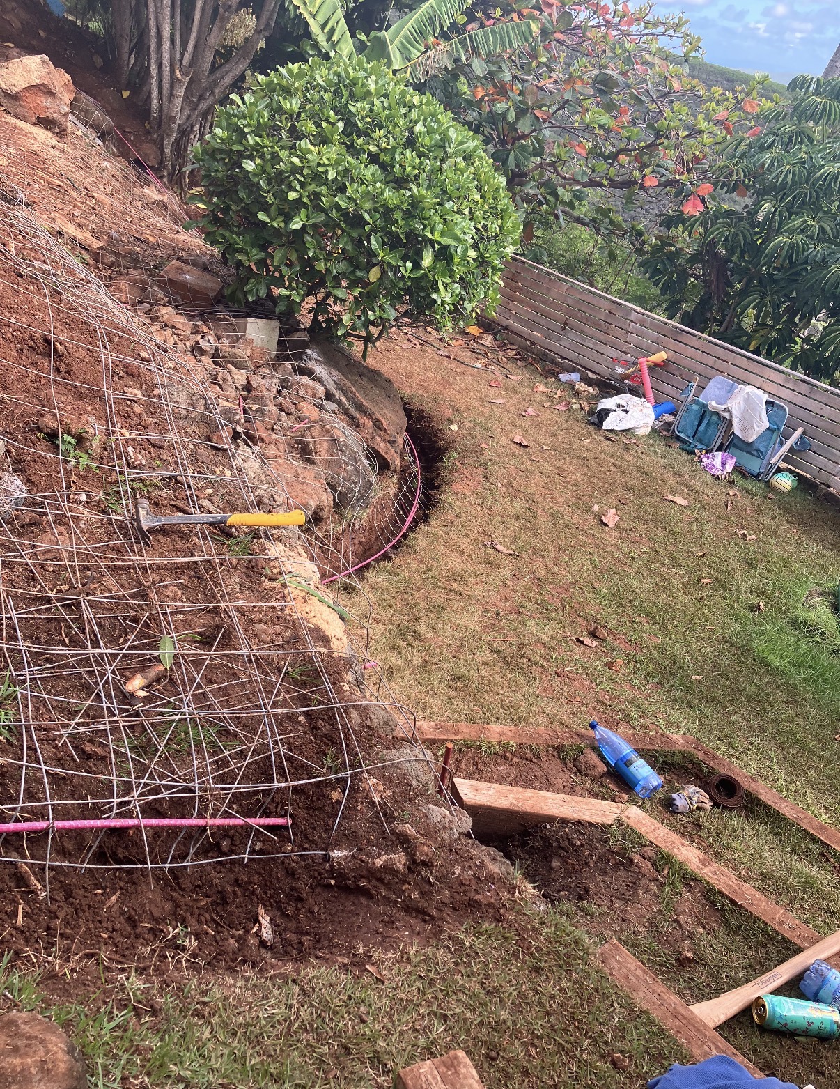Reinforcement mesh laid over a hillside slope before shotcrete placement