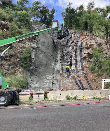 Crew placing shotcrete over reinforcing mesh on the slope at the Board of Water Supply project