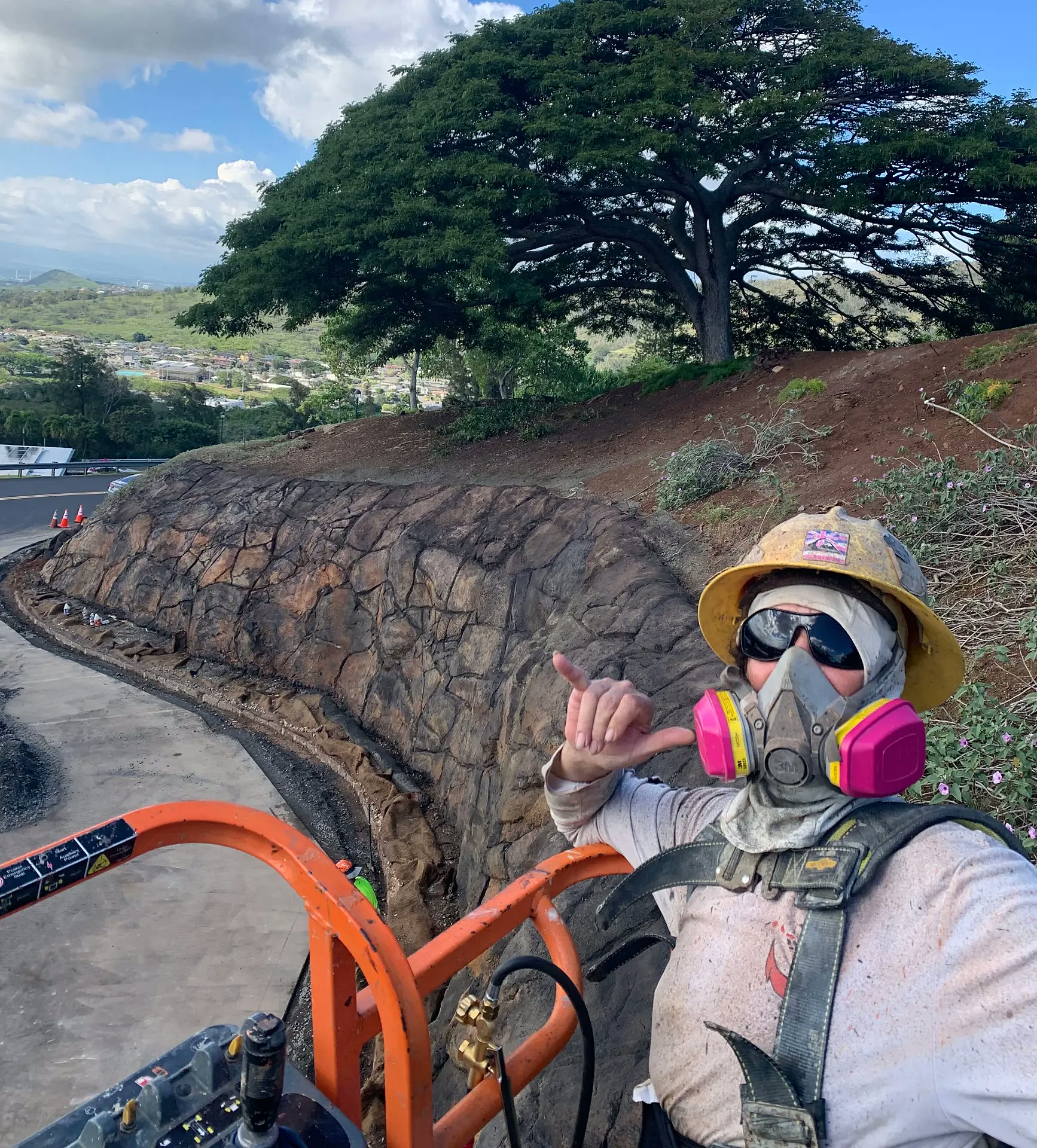 Worker beside finished rock-textured concrete at Kamehameha Schools